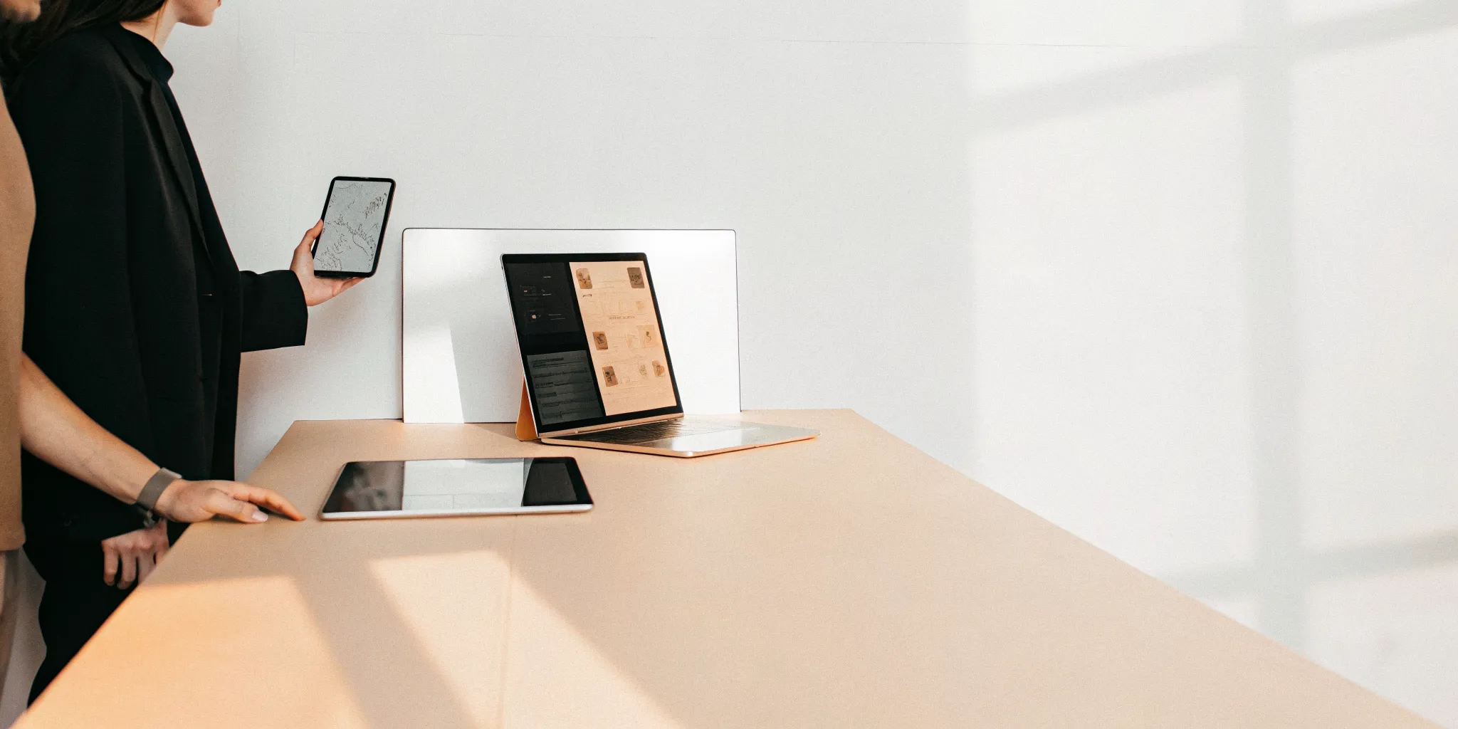 Professionals collaborating on a project with virtual PMO services on a laptop and tablet.