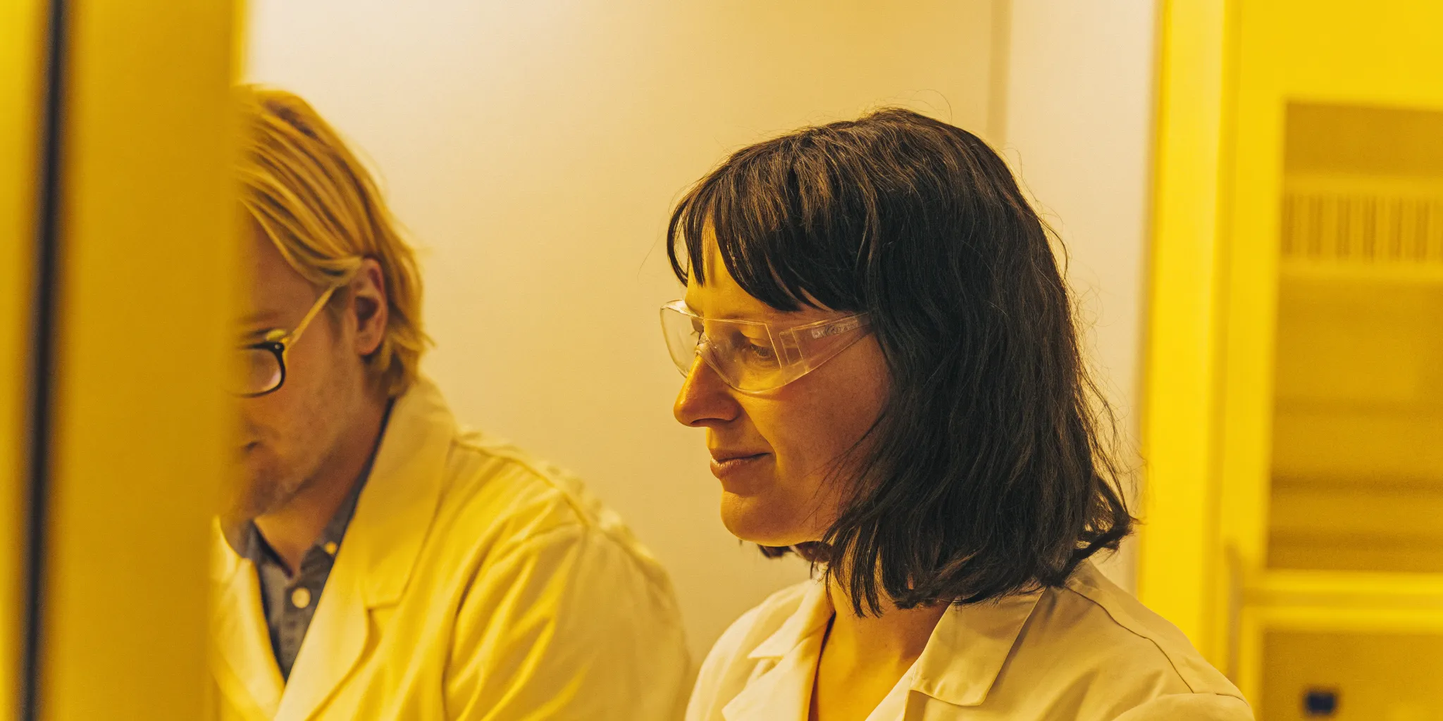 Project manager leading a laboratory team through a LIMS implementation rollout in a modern life sciences facility