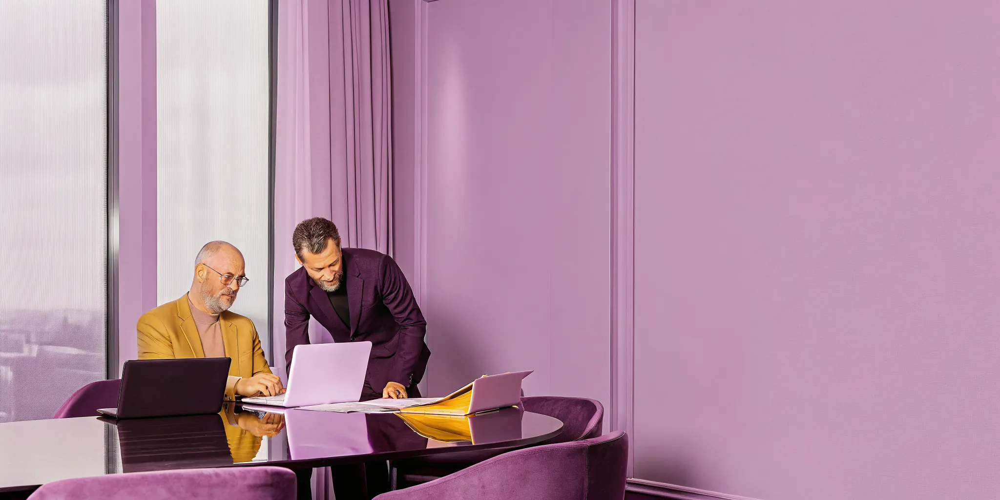 Executives collaborating over project portfolios in a modern boardroom