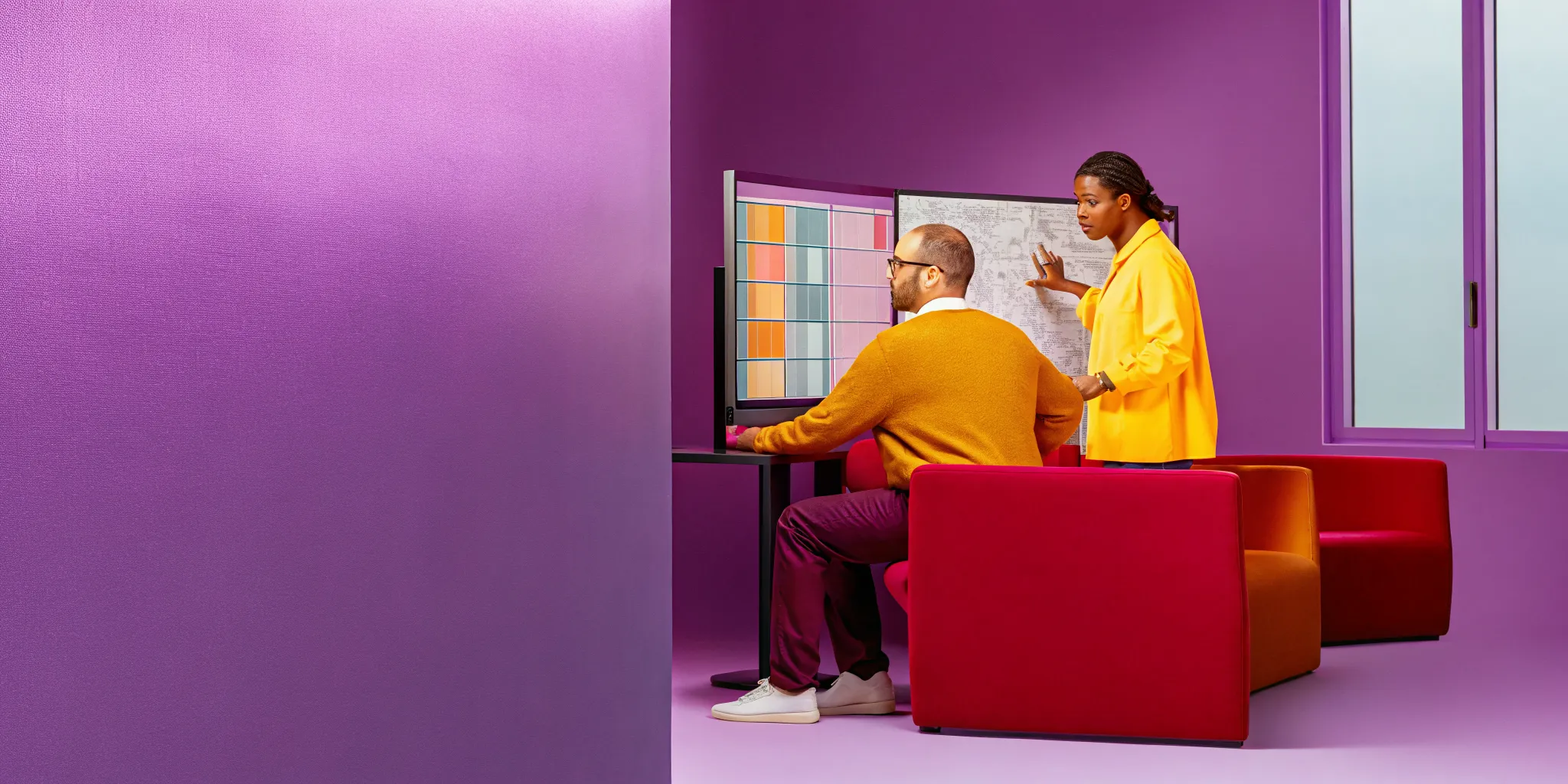 Professional project managers analyzing complex project Gantt charts on digital screens in a modern tech company office