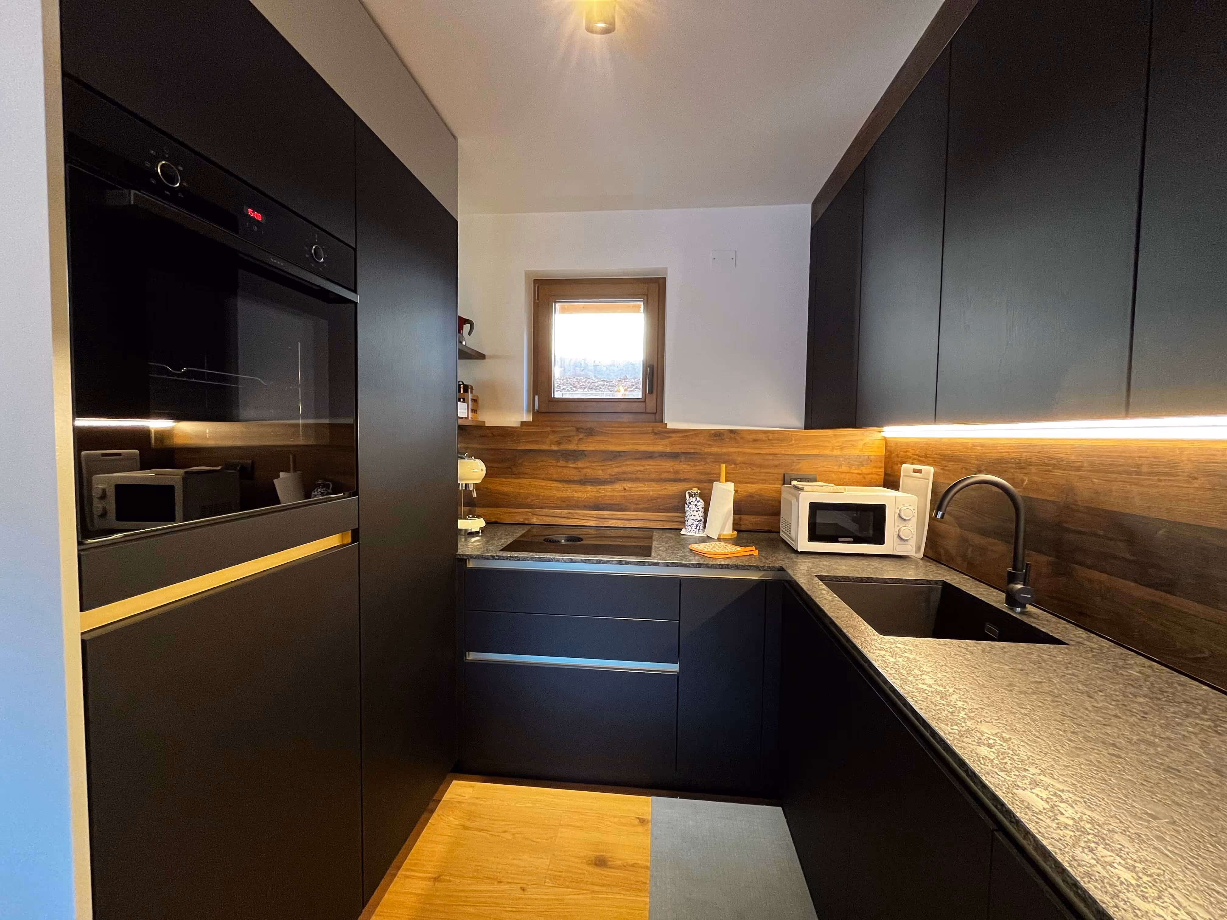 Küchenbereich mit Kaffeemaschine und Backofen und Kühlschrank