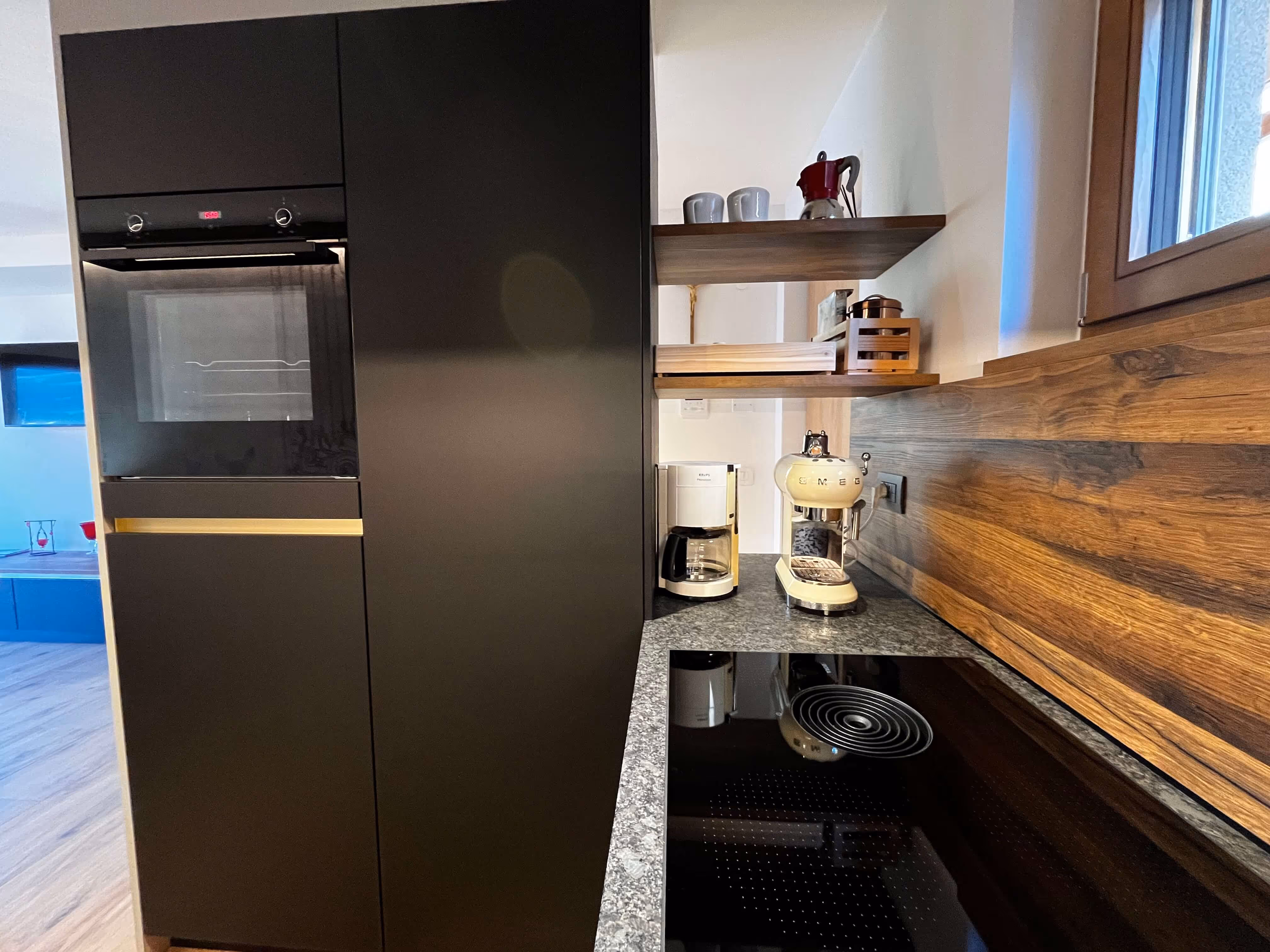 Küchenbereich mit Kaffeemaschine und Backofen und Kühlschrank