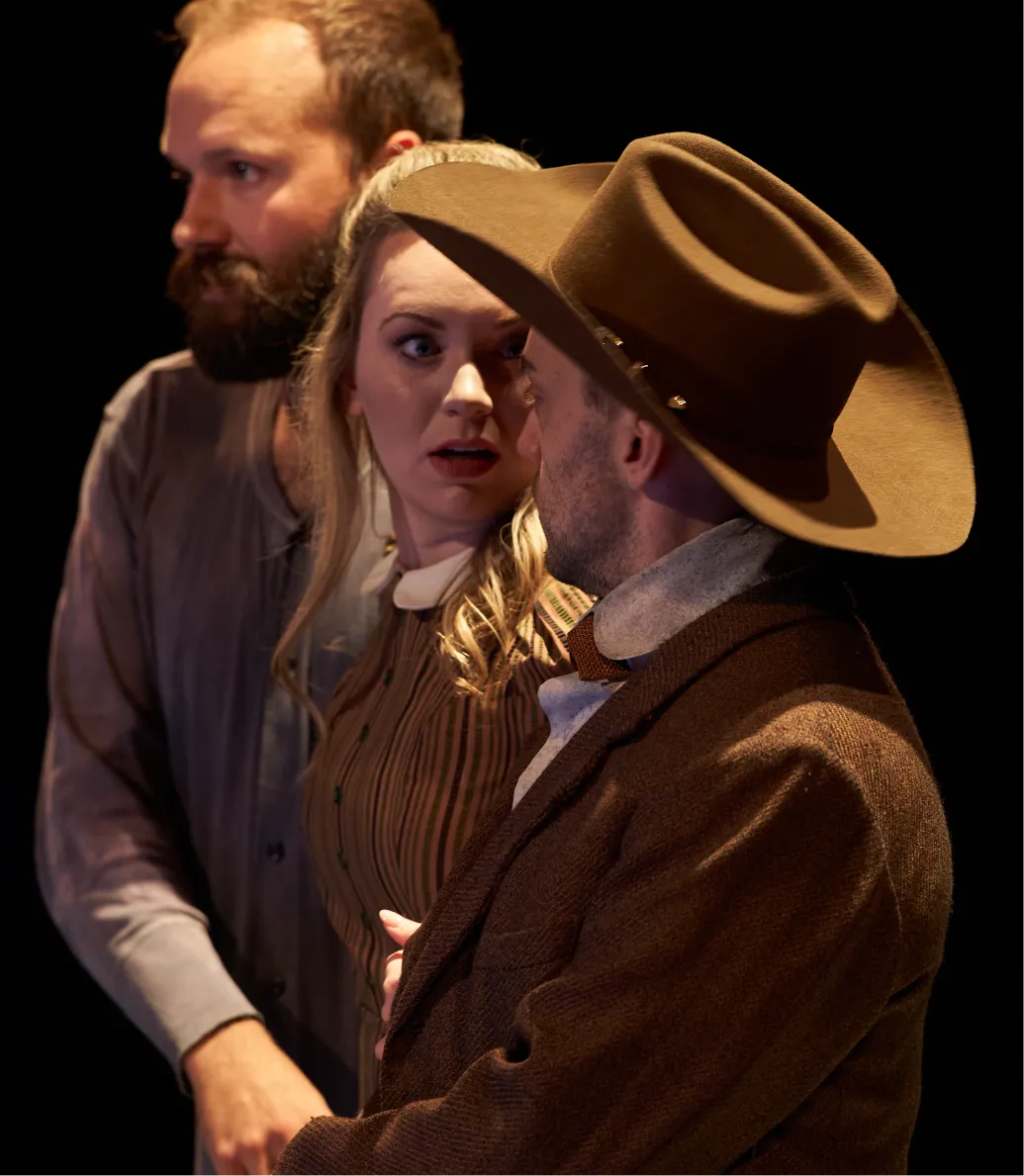 Child holding a vintage camera and taking a photo near a lake.