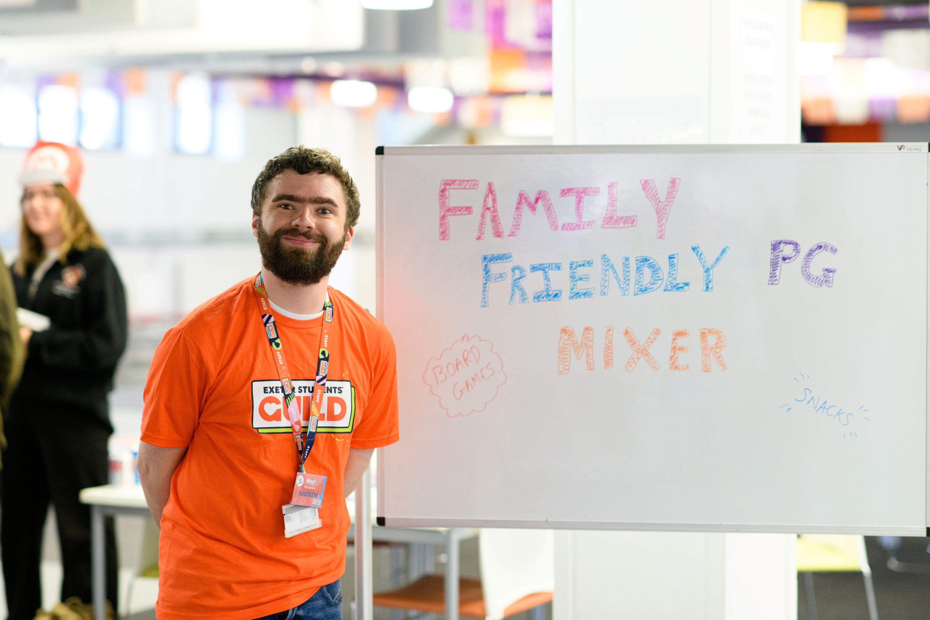 Man in an orange t-shirt smiling at the camera