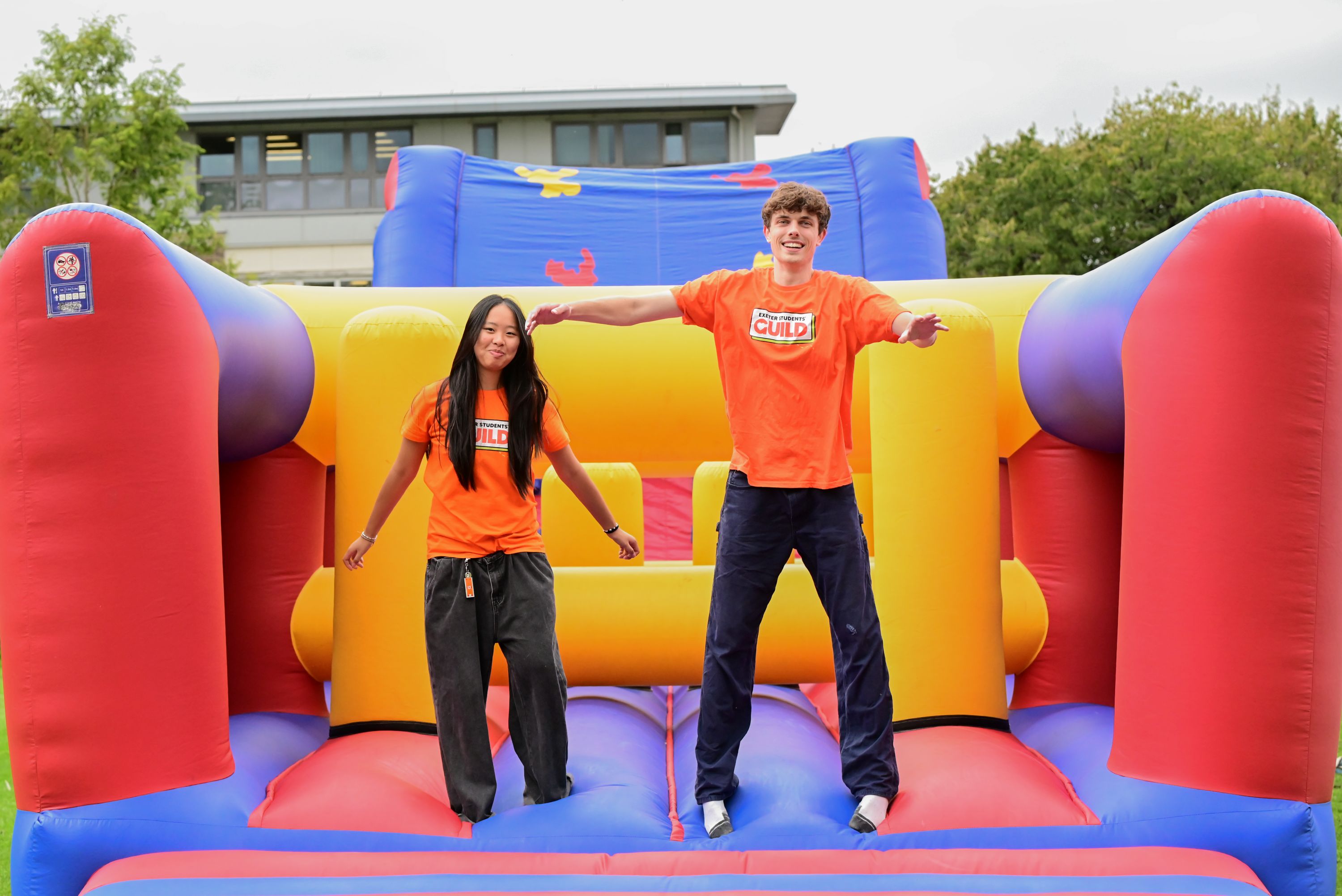 Two students jumping on a bouncy castle