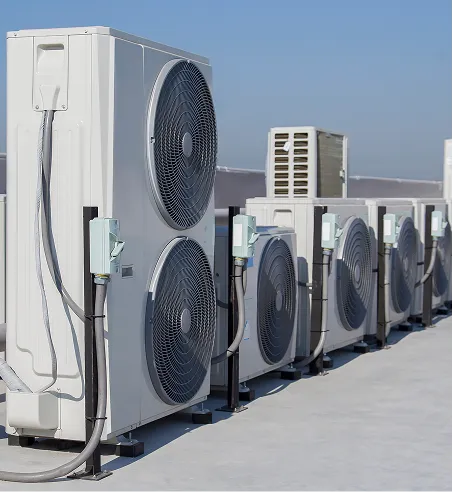 Row of commercial HVAC outdoor units with large fans installed on a rooftop under clear blue sky.