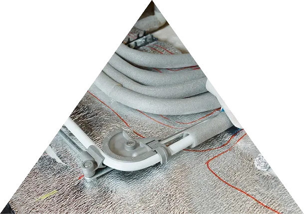 White pipes with foam insulation arranged on reflective foil insulation material with red markings.
