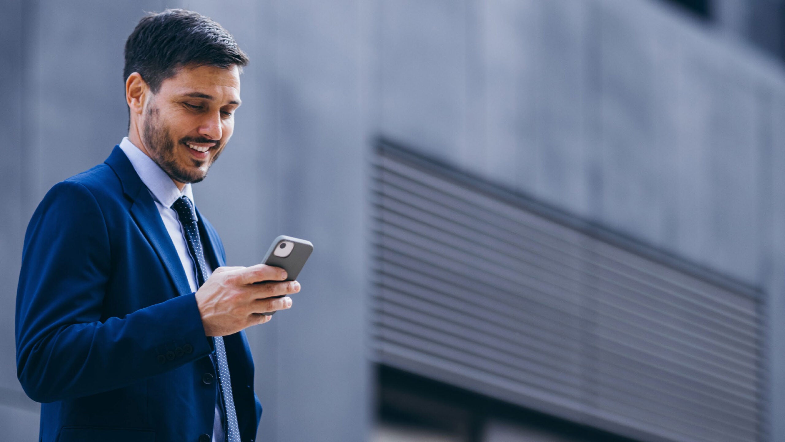 Man is suit looking a phone