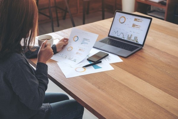 Person looking at charts and graphs on a document.