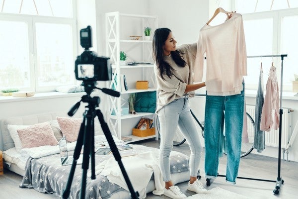 Woman taking photos of clothing for a shop.