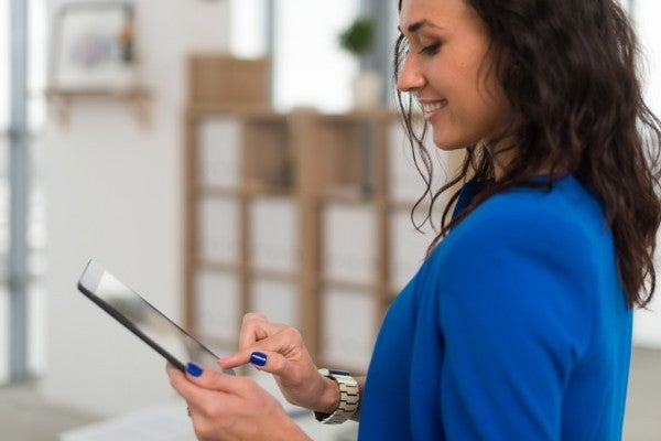 Woman typing on a tablet.