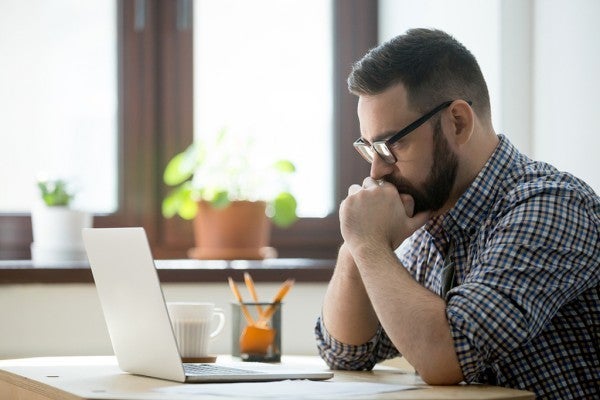 Man staring intently at his computer screen.