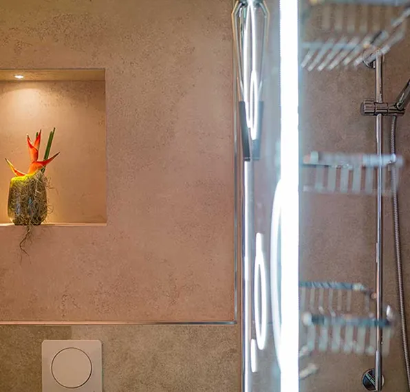 Modernes Badezimmer mit beleuchtetem Wand-Nischenfach und Glasdusche mit Regendusche.