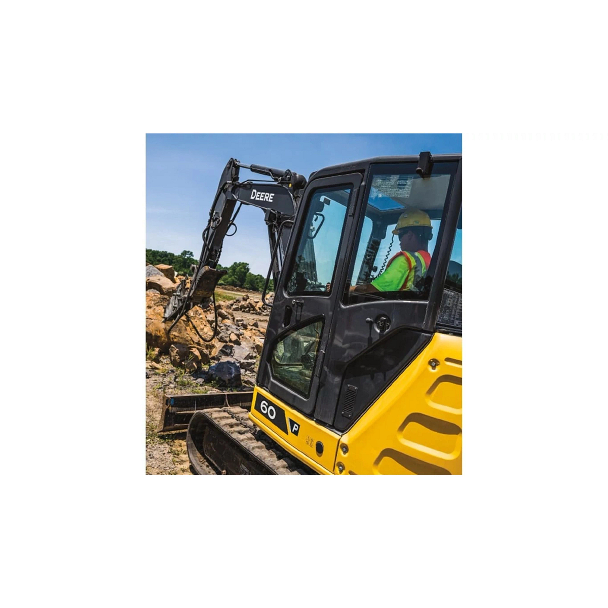 An operator using a 60 P-Tier Excavator to scoop rocks at a worksite