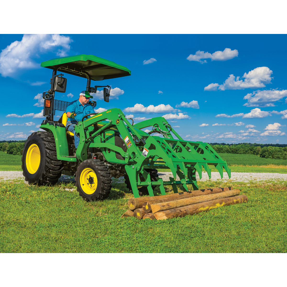 Utility Tractor with Mechanical Grapple and shade canopy in field with logs