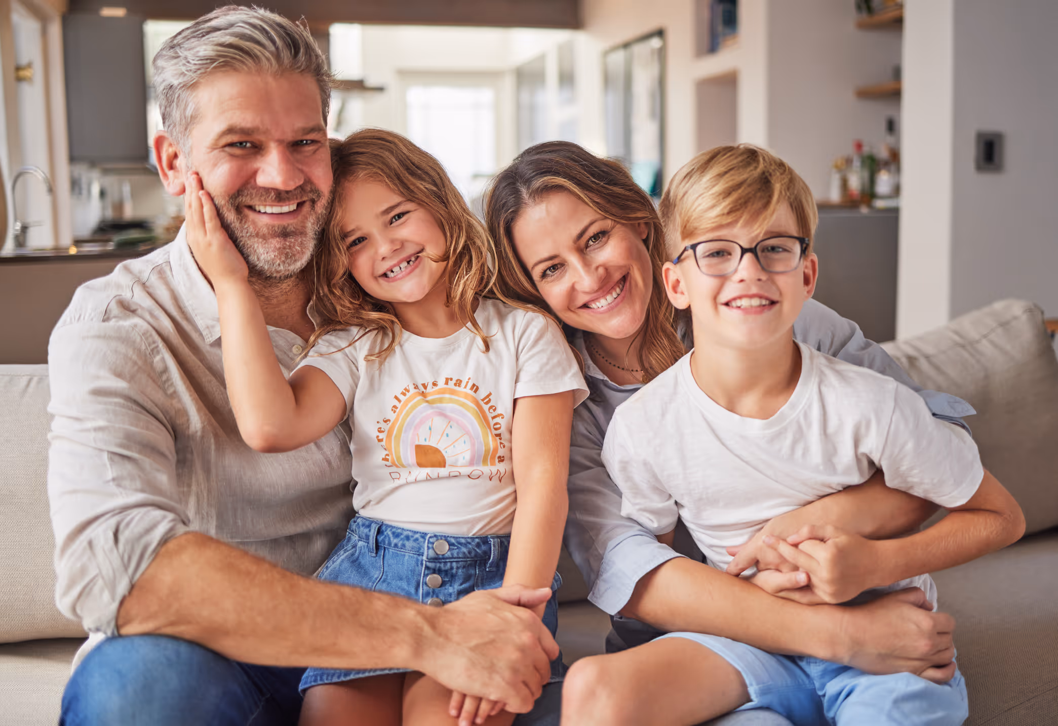 Happy family of four (parents and children) in Orange County, celebrating the positive results of a comprehensive psychoeducational evaluation. 
