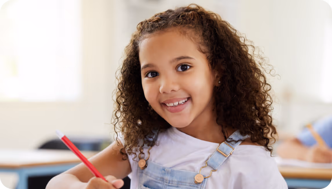 Child smiling working on a written test during IEP consultation. 