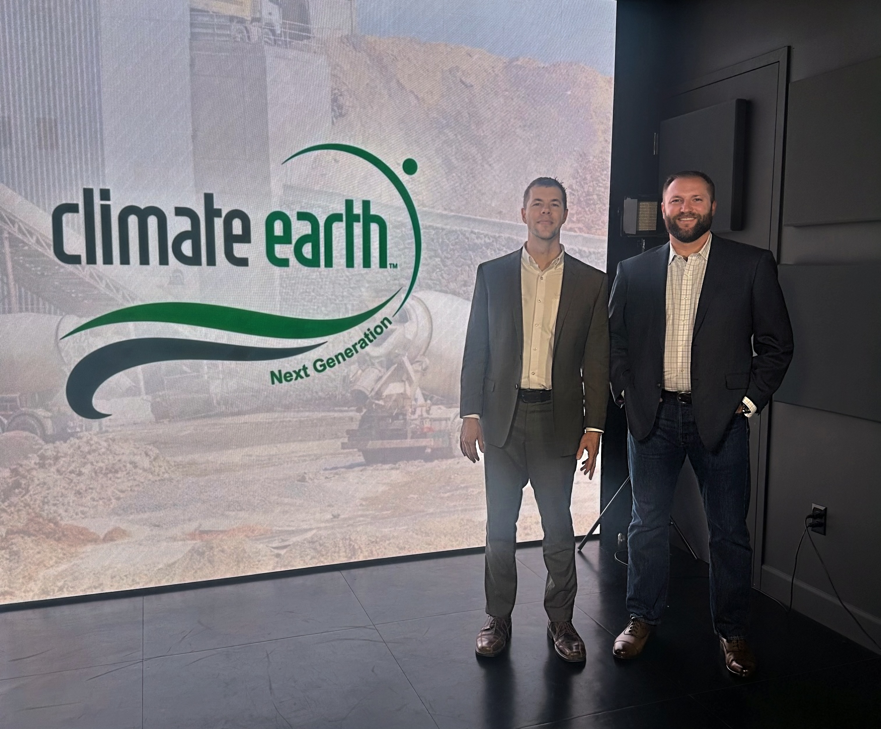 Behind-the-scenes photo from an All Access TV low-carbon concrete segment featuring Karl Laughton, CEO of Climate Earth, and Tyler Ley beside a Climate Earth display.