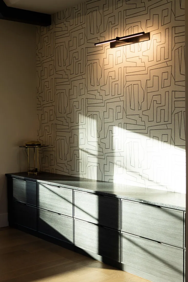 Homeowner cleaning an eggshell-painted wall in a kitchen, demonstrating maintenance practices