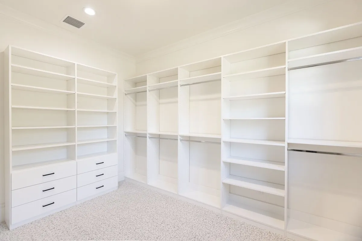 Custom closet installation showcasing stylish storage solutions in a well-lit bedroom