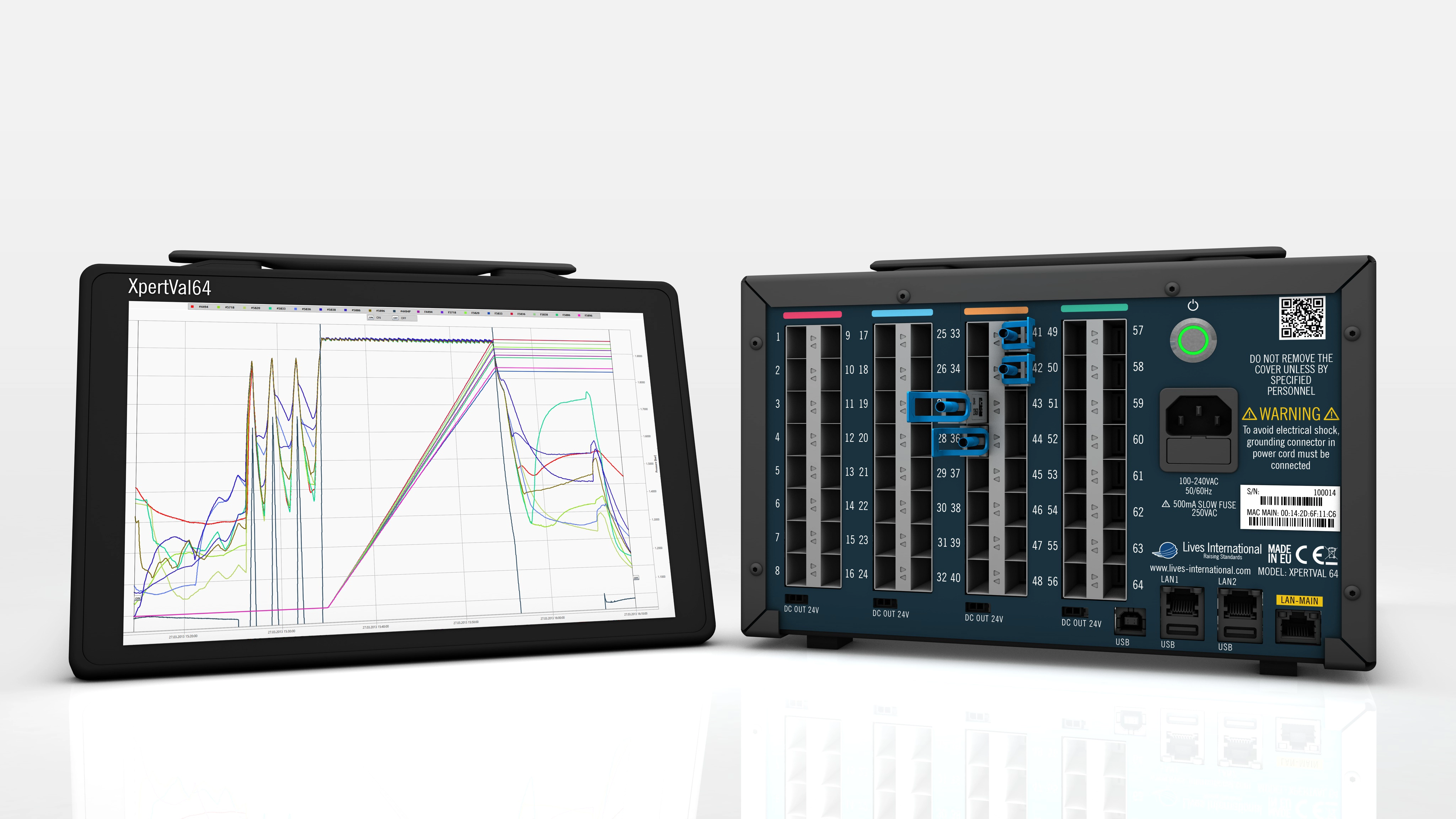XpertVal64 electronic device with a touchscreen displaying colorful performance graphs and a rear panel featuring multiple numbered slots, ports, warning labels, and a green power button.