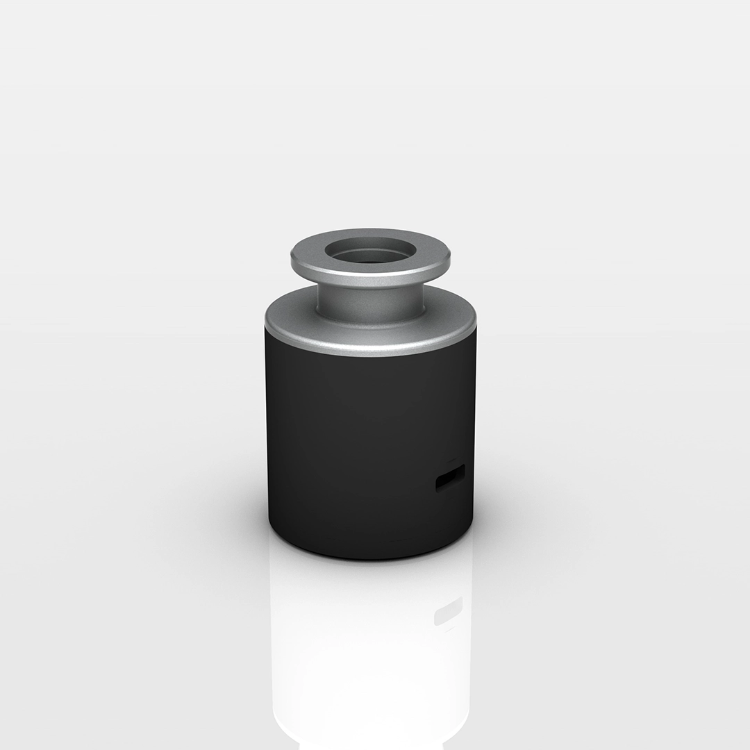 Black and silver cylindrical metal component with a hollow center on top, standing on a reflective surface.