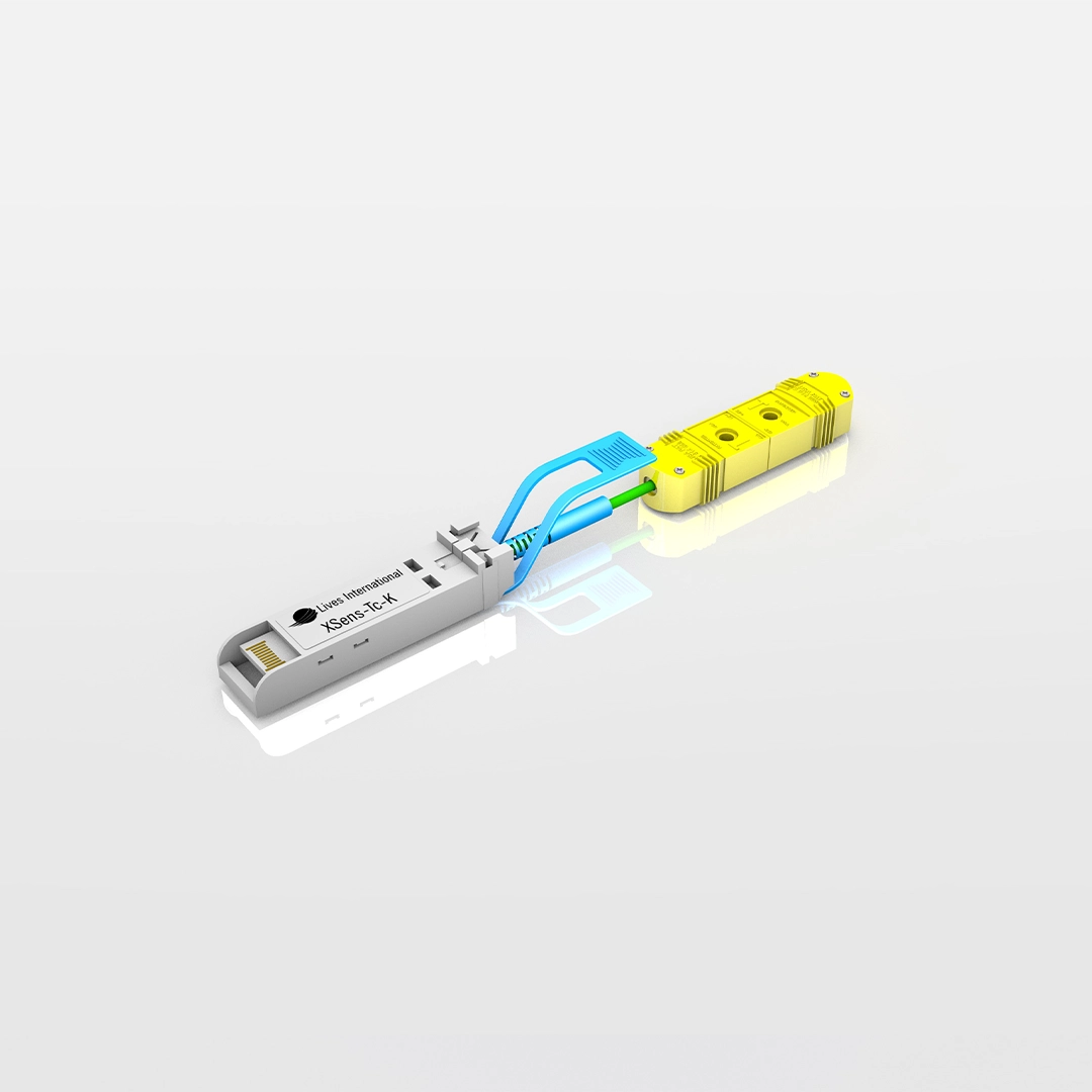 White XSens-TC-K device with blue clamps connected to a yellow sensor block on a reflective surface.