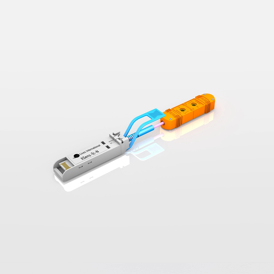 Close-up of an XSens-TC-N sensor device with an orange connector and blue cable clamp on a reflective surface.