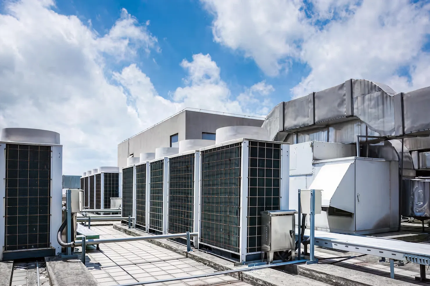 Commercial rooftop HVAC system with multiple condenser units and ductwork