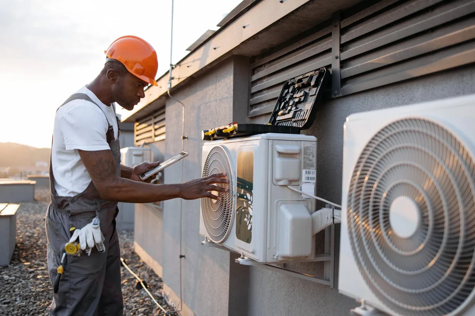 Technician inspecting outdoor commercial air-conditioning units