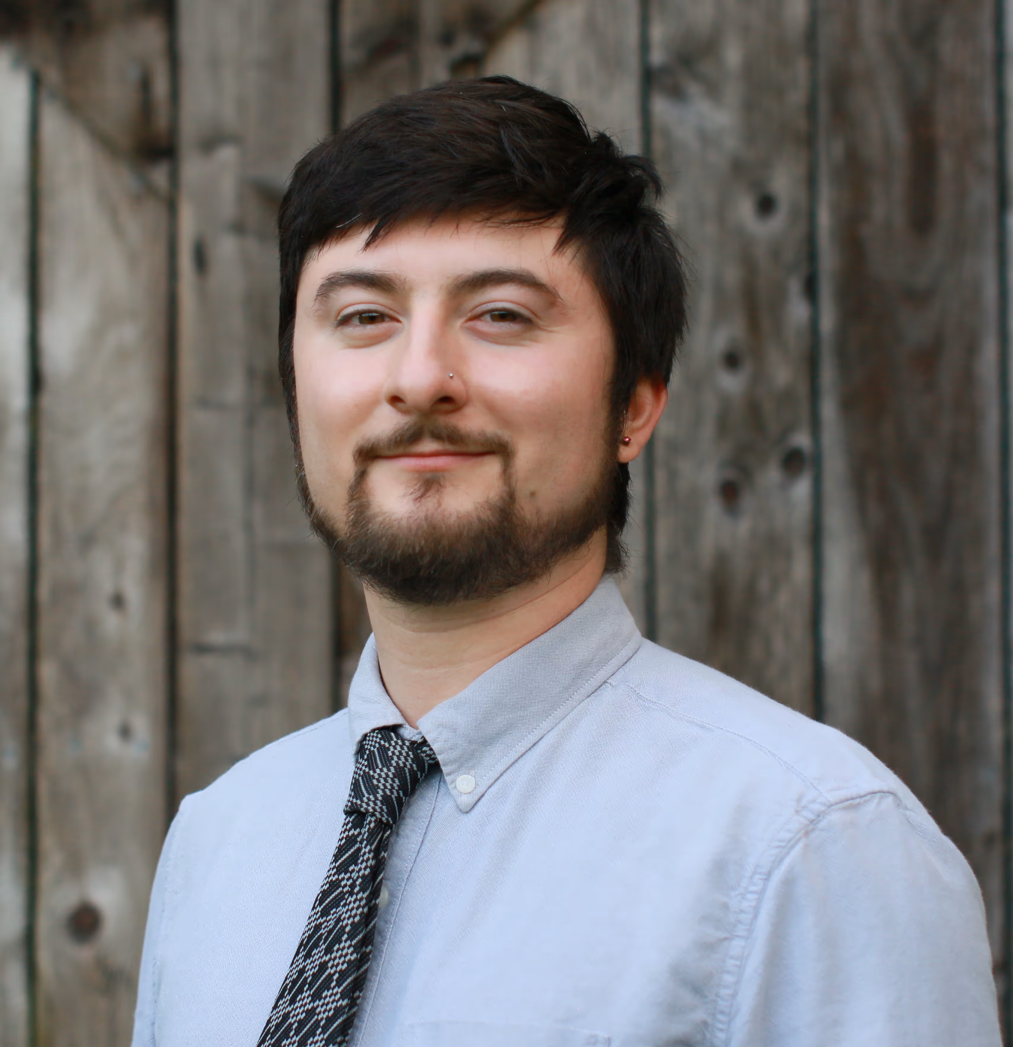 quintin tomasi smiling headshot in front of a barn