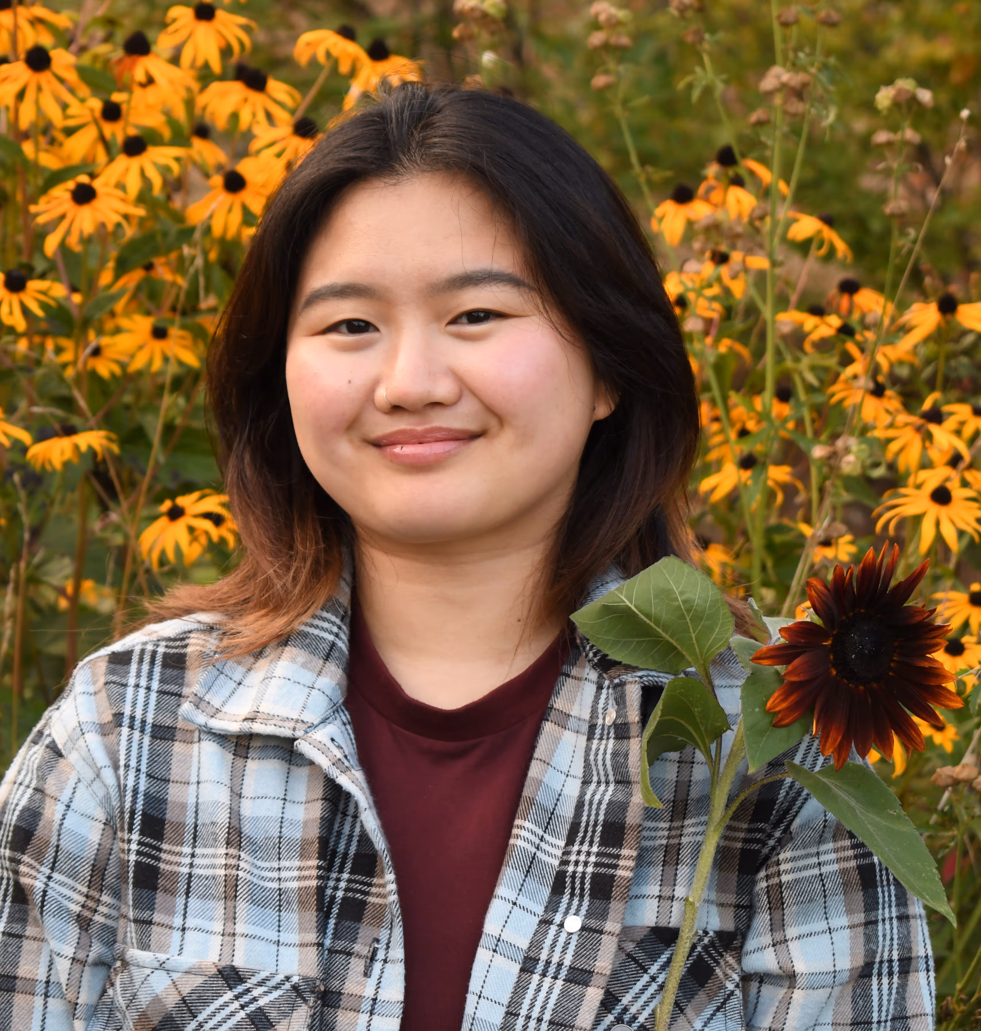 kayla veilleux headshot smiling holding a sunflower