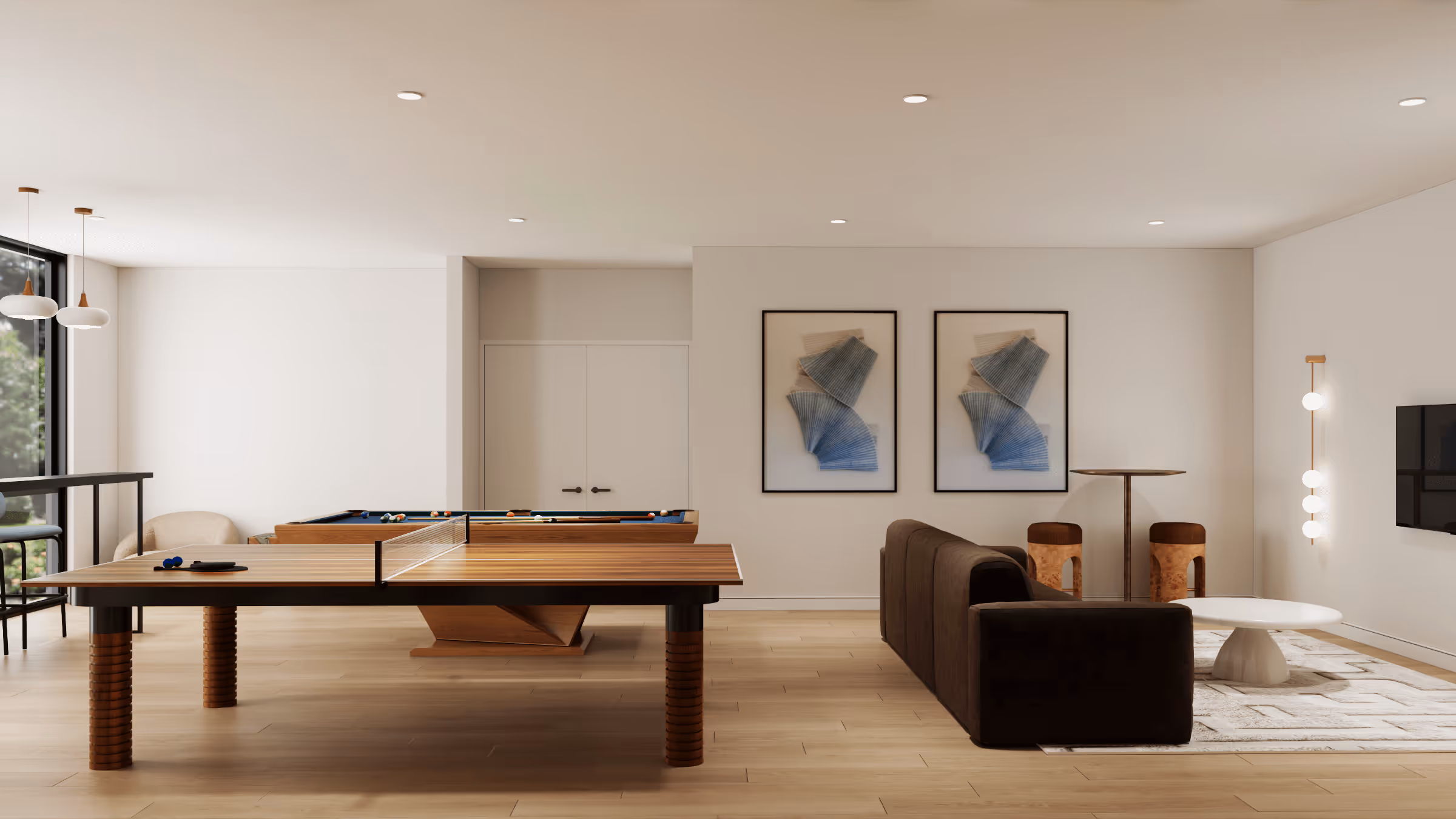 Modern recreation room with a wooden ping pong table, pool table, brown sofa, white coffee table, and framed abstract art on the wall.