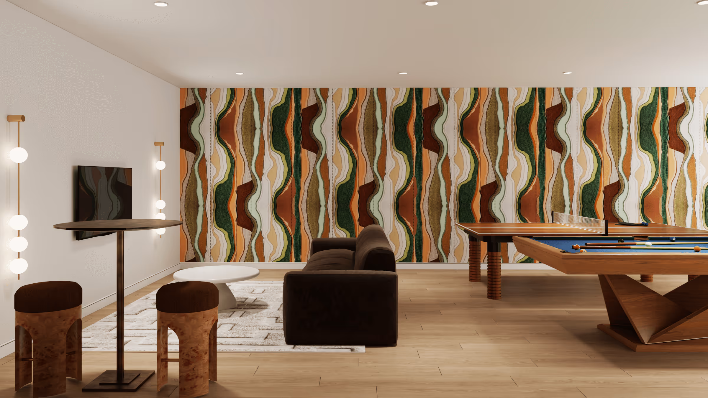 Modern game room with patterned accent wall, brown couch, round white coffee table, two wooden stools, a tall round table, a wall-mounted TV, and wooden pool and ping pong tables.