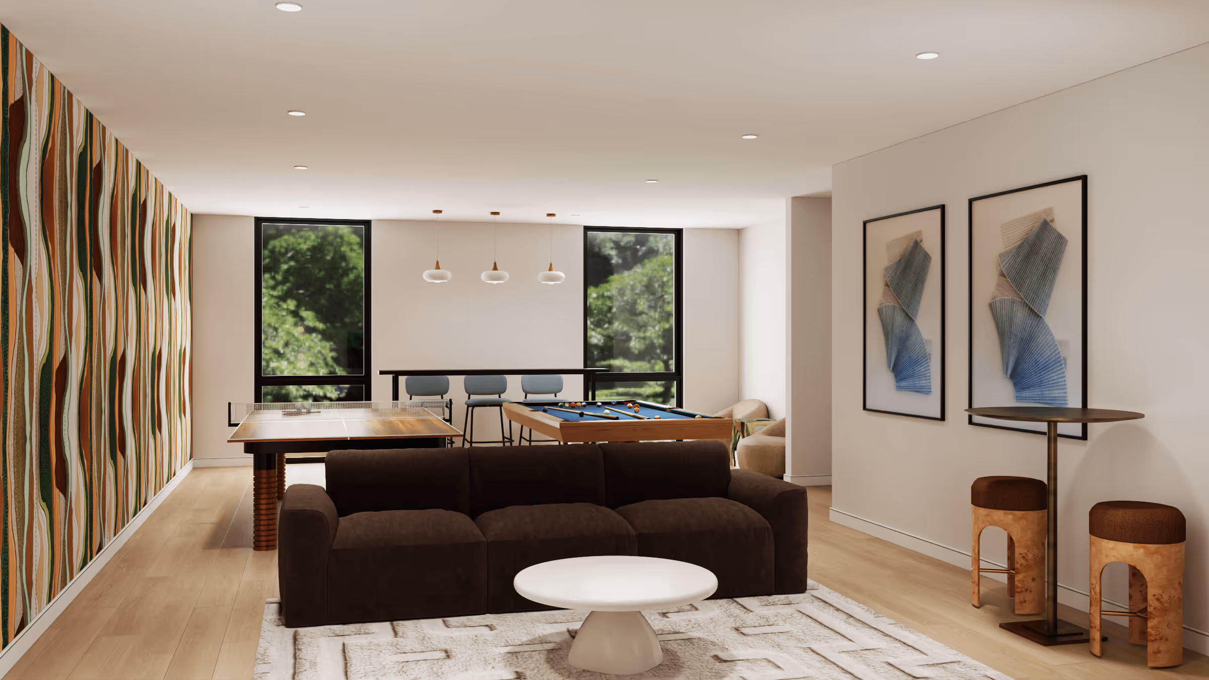 Modern game room with a brown sofa, white round coffee table, ping pong and pool tables, patterned accent wall, and two framed abstract artworks.