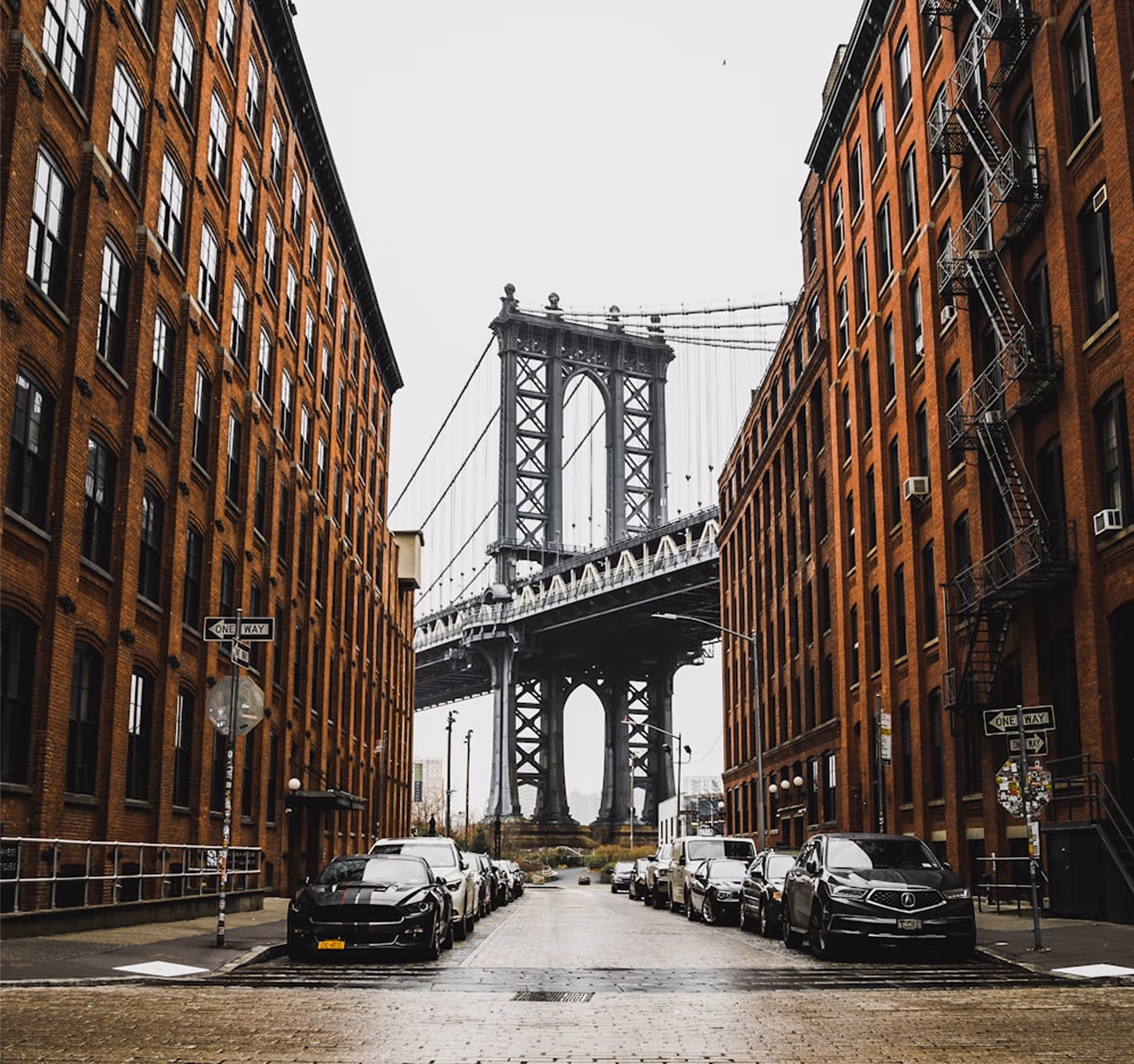 Manhattan Bridge from Luckman Capital framed by historic brick buildings