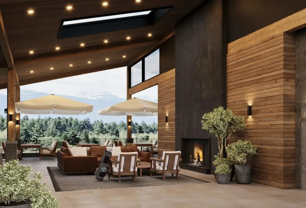 Modern outdoor seating area with brown couches, wooden chairs, two large umbrellas, a fireplace, and mountain view in the background.