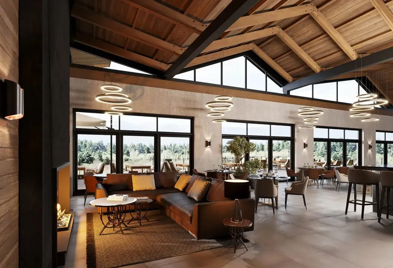 Modern living room with a large brown leather sectional sofa, round coffee tables, hanging ring chandeliers, and a fireplace under a high wooden ceiling with large windows showing an outdoor view.