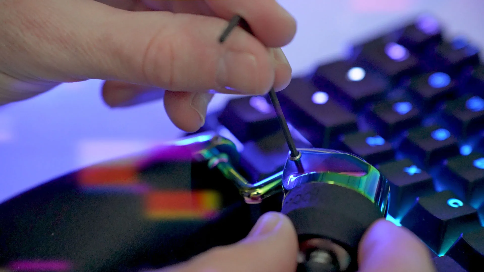 Hands adjusting the Mimic with a small tool over illuminated keys.