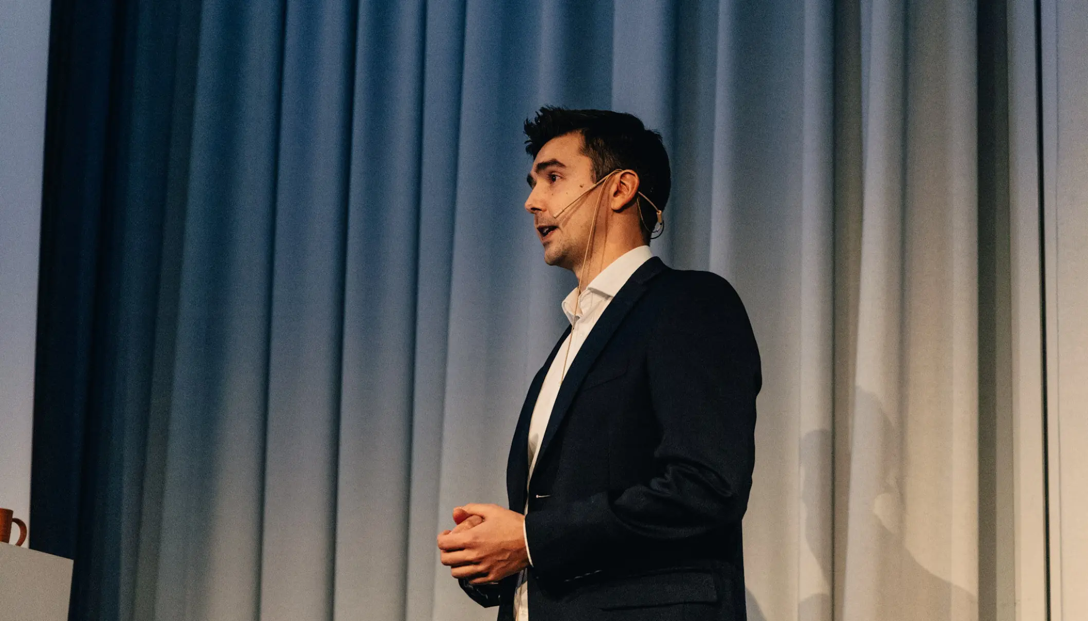 Andreas de Lange på scenen med foredrag om teknologimiljøet i Bergen. 