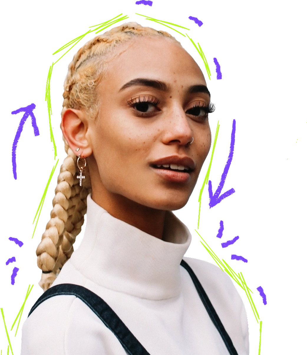 Young woman with blonde braided hair wearing a white turtleneck and black suspenders with purple and green graphic accents.