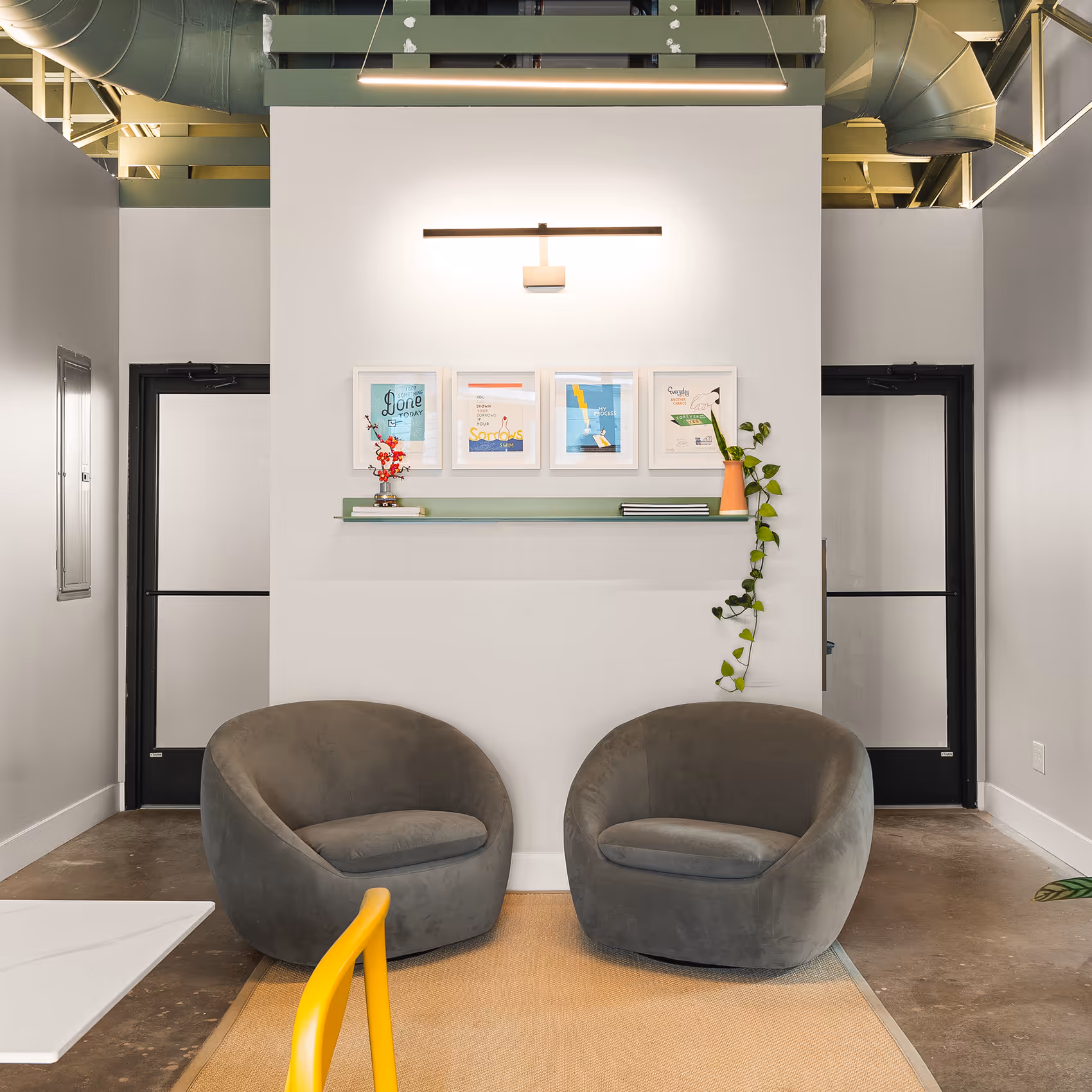 Common space near the shared kitchen at Sideyard with two comfy chairs next to one another.