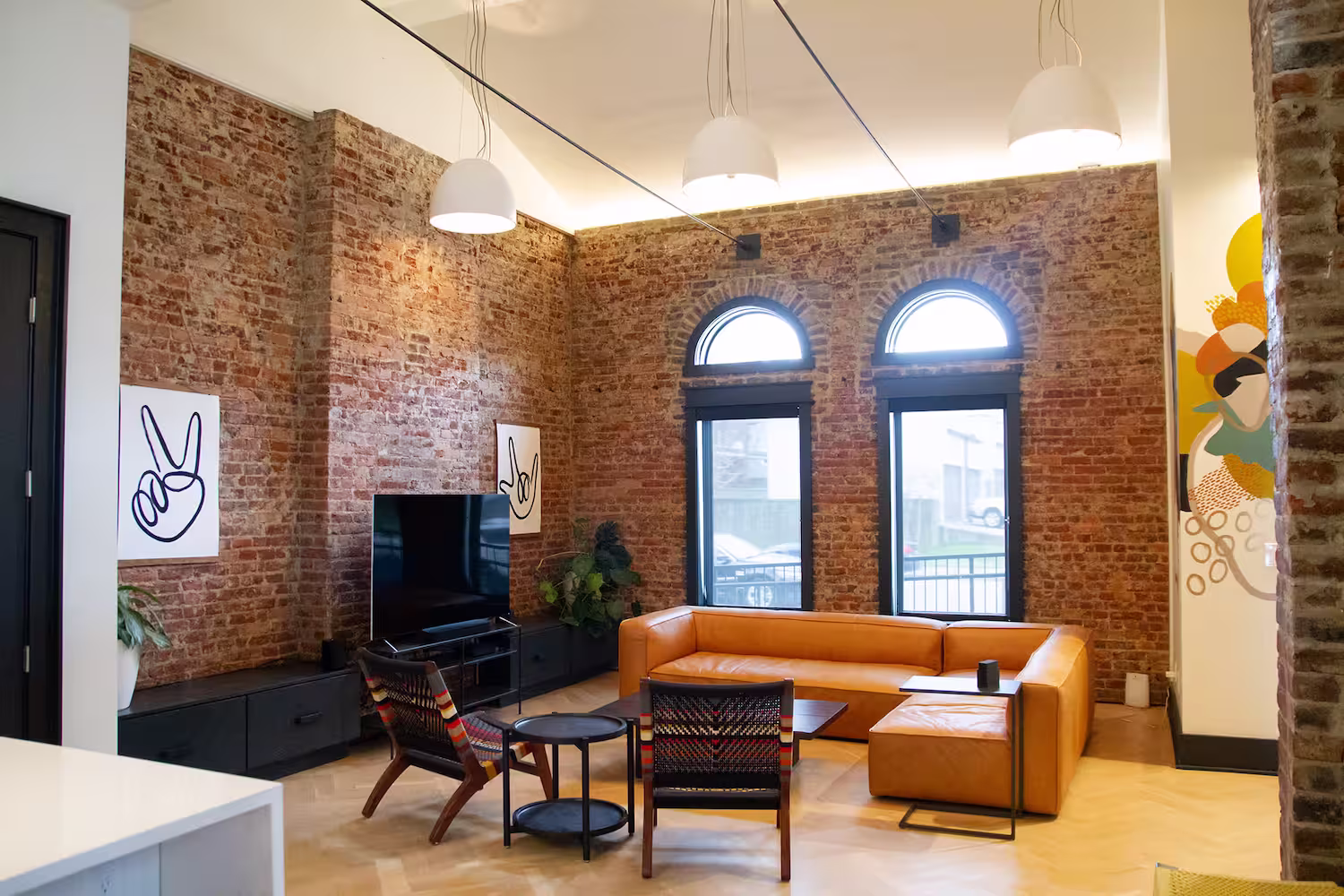 Living room with sofas, a television, and 2 arched windows