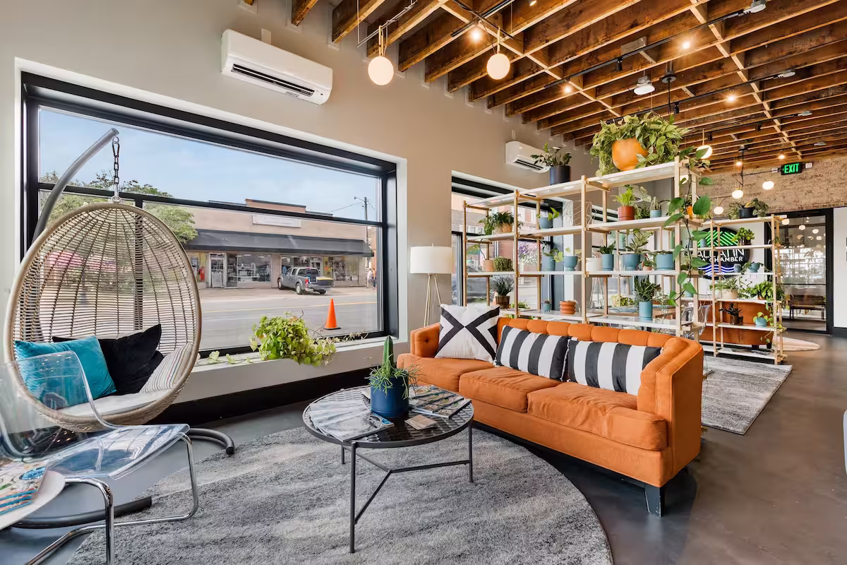 Seating area inside of the office complex with colorful furniture and shelves near a large window
