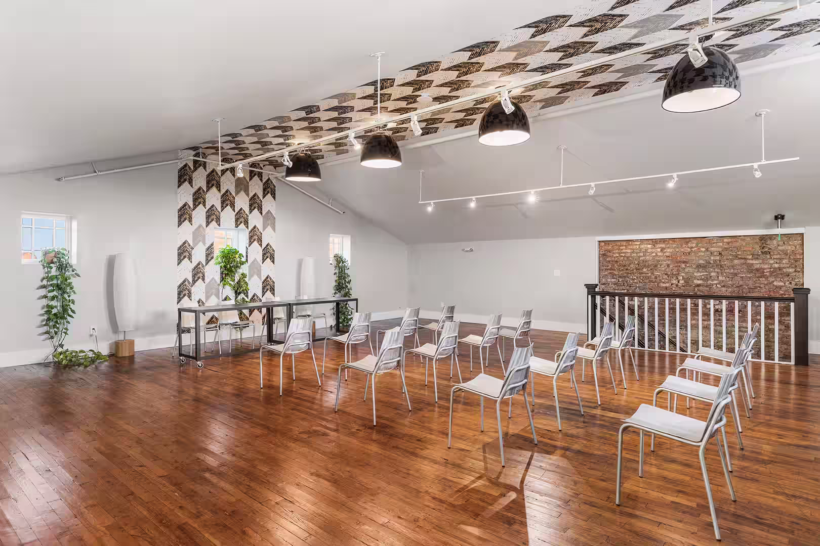 Meeting room with wooden floors an several rows of chairs all facing forward.