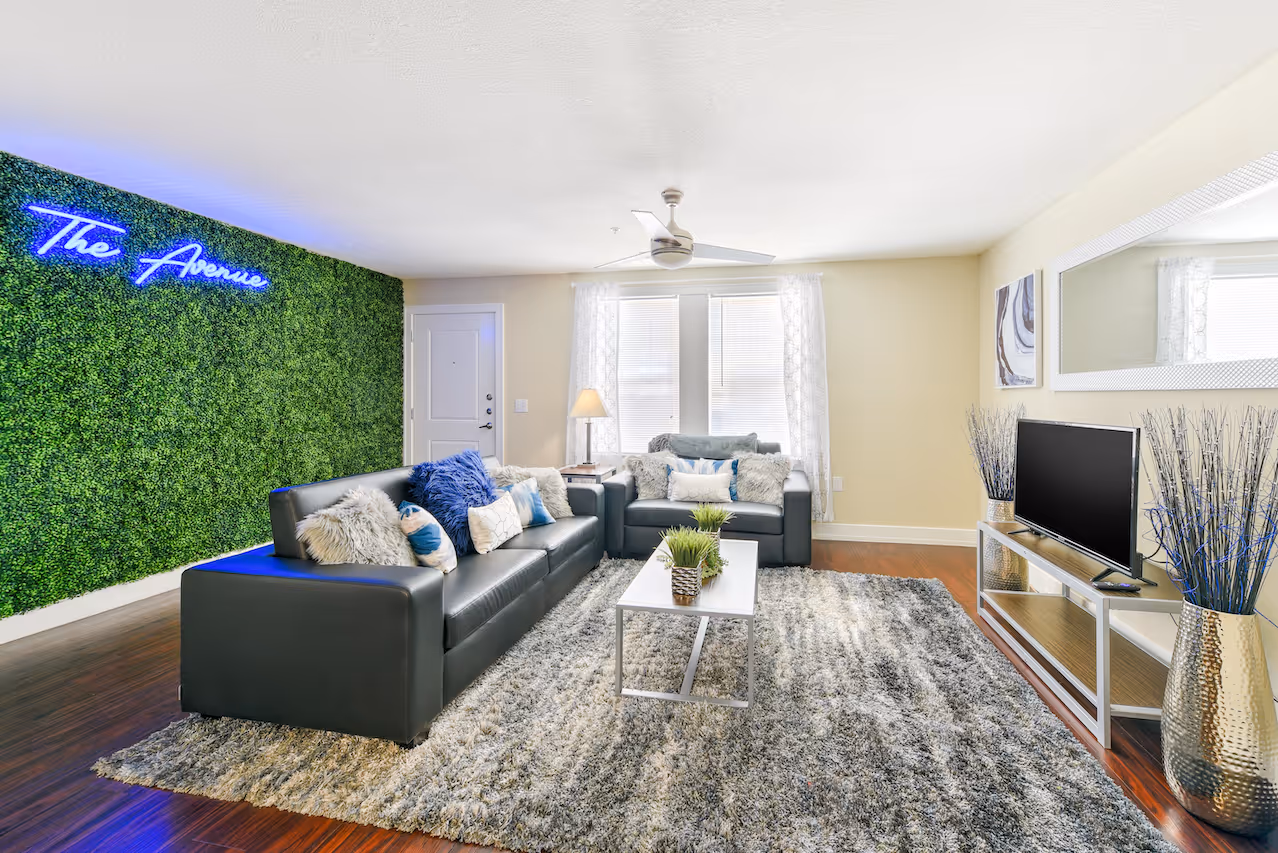 Fully furnished living room with accent greenery wall 