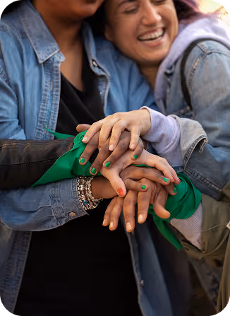 Amigos sonriendo juntando sus manos una encima de la otra
