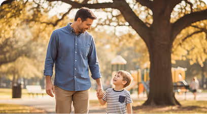 Hombre adulto caminando de la mano con un niño pequeño en un parque durante el día.