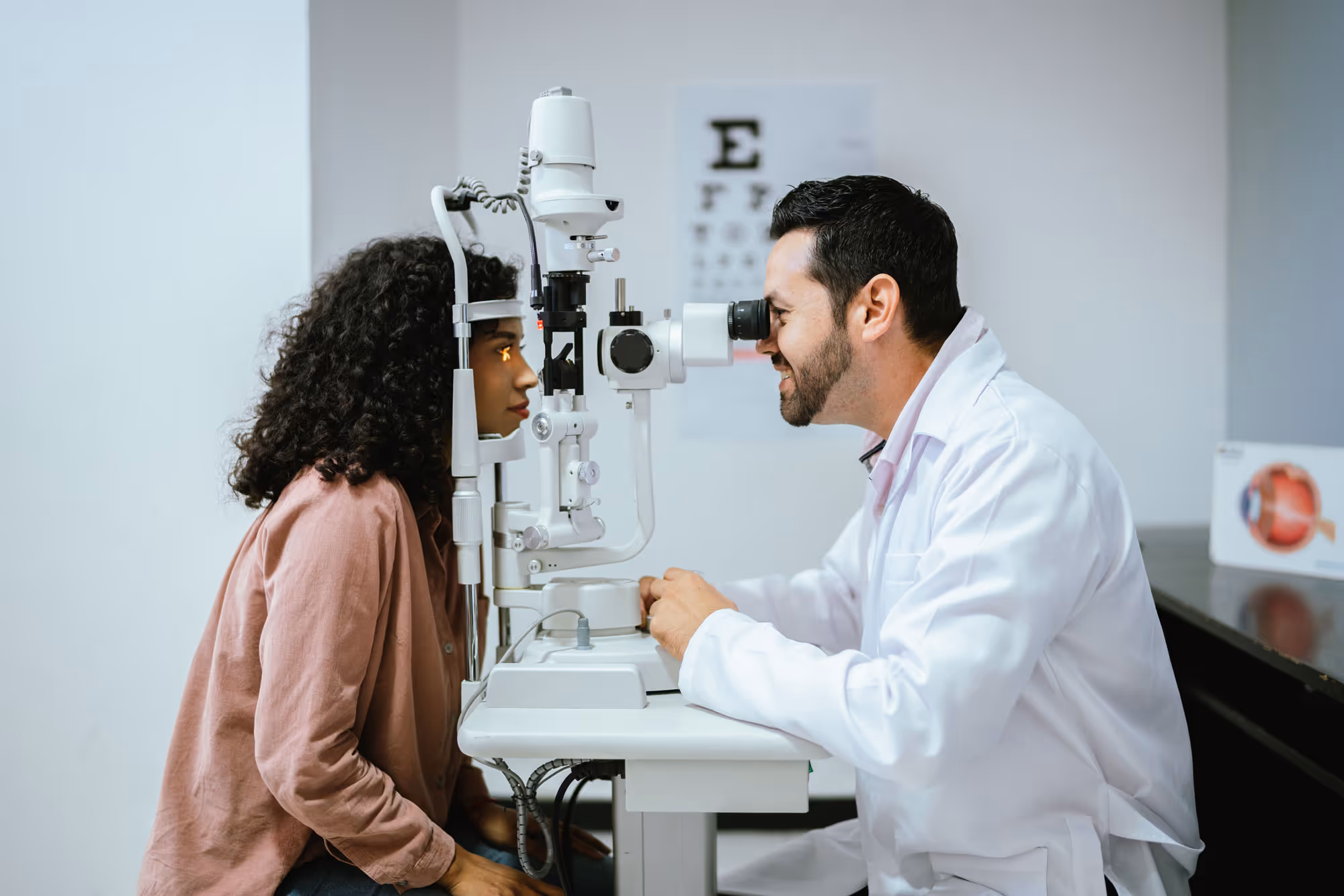 An optometrist is giving an eye exam to a woman in his office.