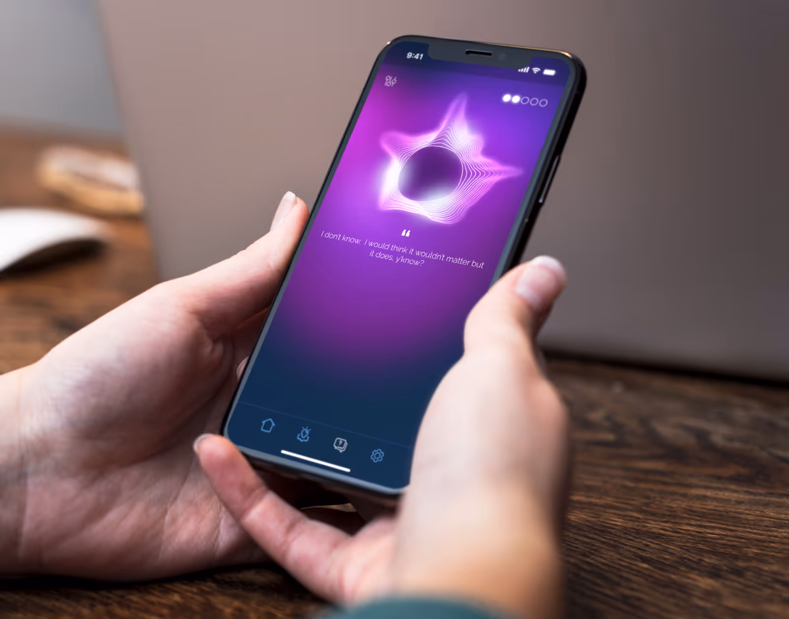 Person holding a smartphone displaying a purple screen with a glowing star-shaped soundwave and a quote reading, 'I don't know. I would think it wouldn't matter but it does, y'know?'